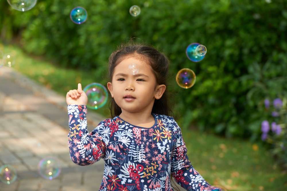 girl playing with bubbles